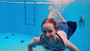 Teen girl Avenna is swimming in the pool